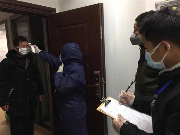 鄭愛民在小區(qū)上門測量住戶體溫.jpg